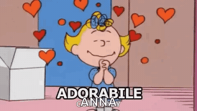 A Cartoon Of A Girl With Hearts Around Her And The Words `` Adorabile Anna '' Written Above Her . GIF