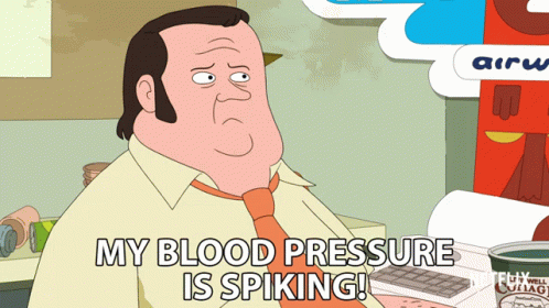 A Cartoon Of A Man Sitting At A Desk Saying " My Blood Pressure Is Spiking " GIF