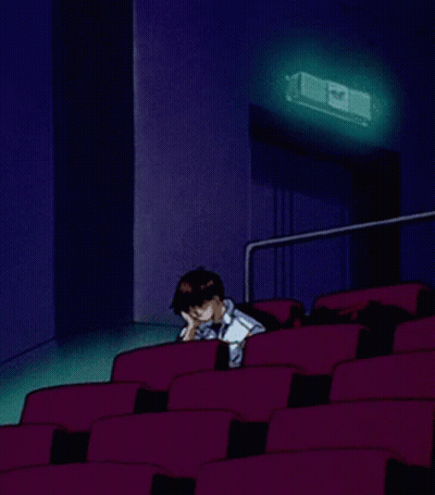 A Cartoon Of A Man Sitting In An Auditorium With A Projector Behind Him GIF