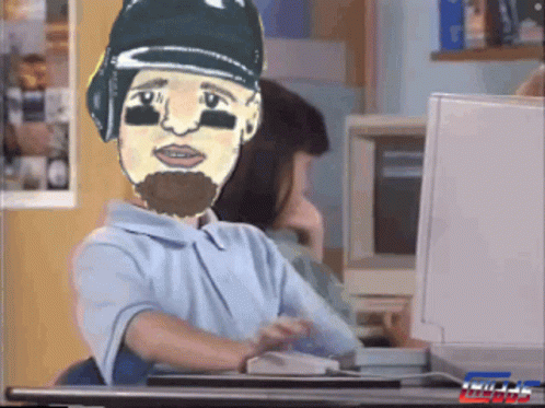 A Cartoon Of A Man With A Beard Is Sitting At A Desk GIF