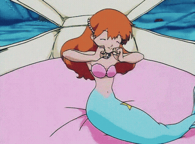 A Cartoon Of A Mermaid Laying On A Bed With Her Eyes Closed GIF