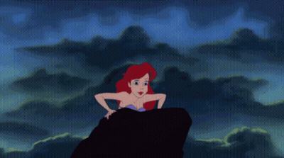 A Cartoon Of A Mermaid Sitting On A Rock In The Ocean GIF