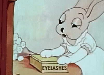A Cartoon Of A Rabbit Looking At A Box Of Eyelashes GIF