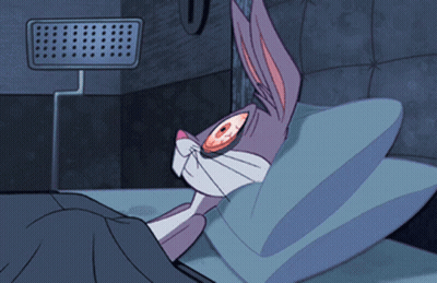 A Cartoon Of Bugs Bunny Laying In Bed With His Eyes Open GIF