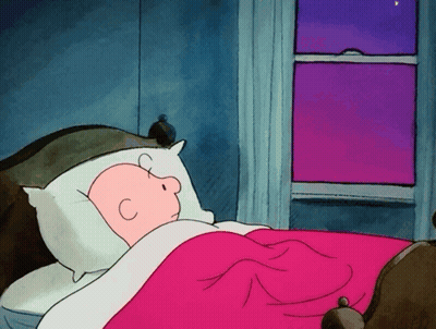 A Cartoon Of Charlie Brown Sleeping In A Bed GIF