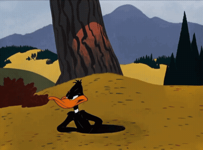 A Cartoon Of Daffy Duck Laying In The Dirt Near A Tree GIF