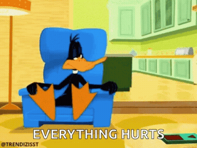 A Cartoon Of Daffy Duck Sitting In A Chair With The Words Everything Hurts Written Below Him . GIF