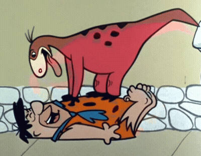 A Cartoon Of Flintstone Laying On The Ground With A Dinosaur On His Back GIF