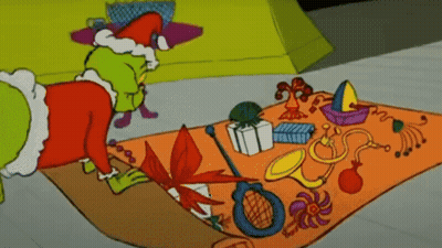 A Cartoon Of Grinch Laying On A Rug With Toys On It GIF