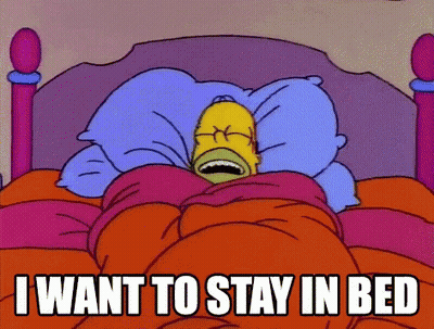 A Cartoon Of Homer Simpson Laying In Bed With The Words " I Want To Stay In Bed " Above Him GIF