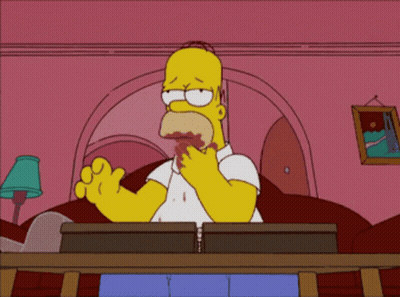 A Cartoon Of Homer Simpson Sitting At A Desk GIF