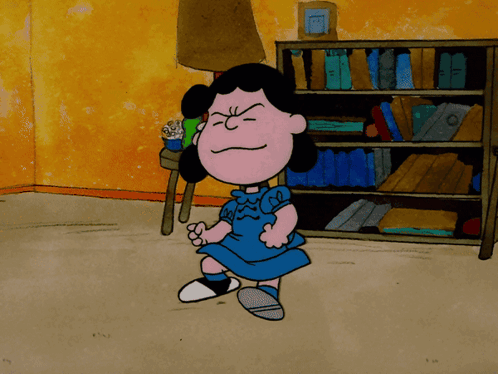 A Cartoon Of Lucy Brown Standing In Front Of A Bookcase GIF