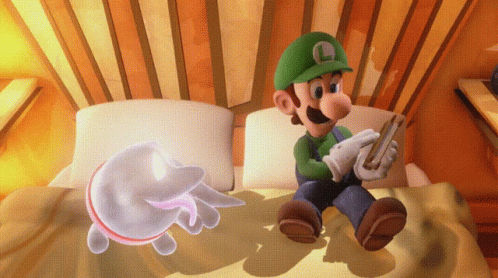 A Cartoon Of Luigi Sitting On A Bed Playing A Video Game GIF