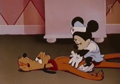 A Cartoon Of Mickey Mouse And Pluto Laying On The Ground GIF