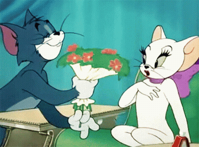 A Cartoon Of Tom And Jerry Sitting At A Desk With Tom Holding A Bouquet Of Flowers GIF