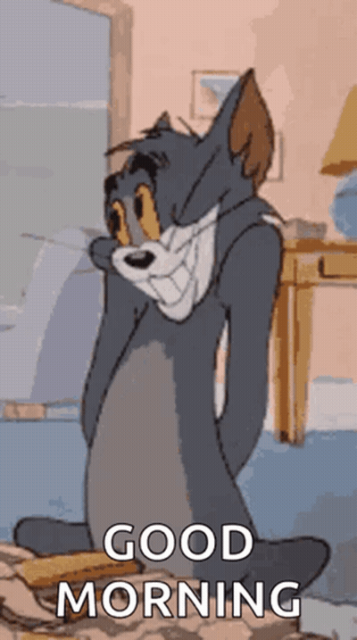 A Cartoon Of Tom From Tom And Jerry Is Sitting On A Bed With His Eyes Closed And Says Good Morning . GIF