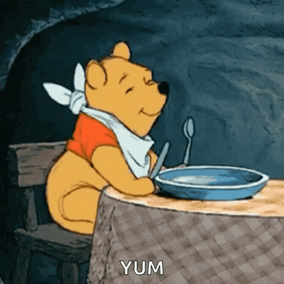 A Cartoon Of Winnie The Pooh Sitting At A Table With A Bowl Of Food And A Spoon . GIF