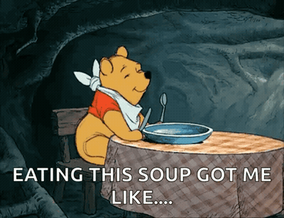 A Cartoon Of Winnie The Pooh Sitting At A Table With A Bowl Of Soup GIF