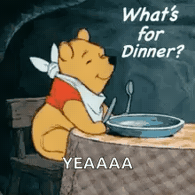 A Cartoon Of Winnie The Pooh Sitting At A Table With A Plate Of Food And A Spoon . GIF