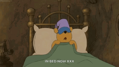 A Cartoon Of Winnie The Pooh Sleeping In A Bed GIF