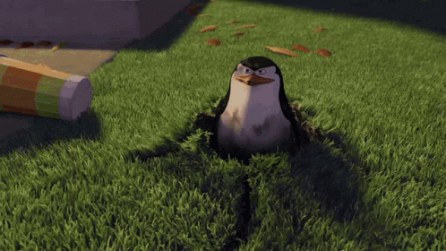 A Cartoon Penguin Is Sitting In The Grass And Looking At The Camera GIF
