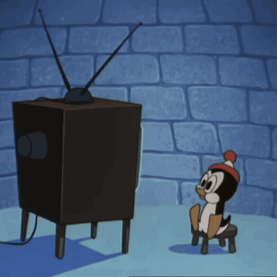A Cartoon Penguin Is Sitting On A Stool Watching A Tv GIF