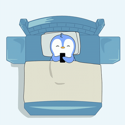 A Cartoon Penguin Is Sleeping In A Bed With A Cell Phone On The Blanket GIF
