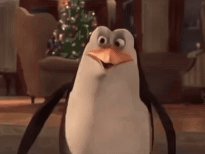 A Cartoon Penguin Is Standing In Front Of A Christmas Tree . GIF