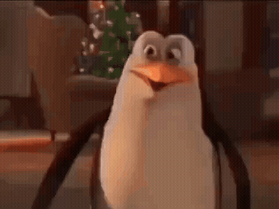 A Cartoon Penguin Is Standing In Front Of A Christmas Tree . GIF