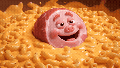 A Cartoon Pig Is In A Bowl Of Macaroni And Cheese GIF