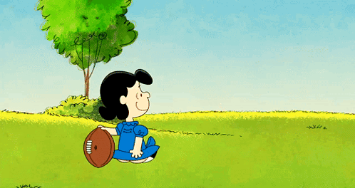 A Cartoon Shows Charlie Brown And Lucy Brown Playing With A Football GIF