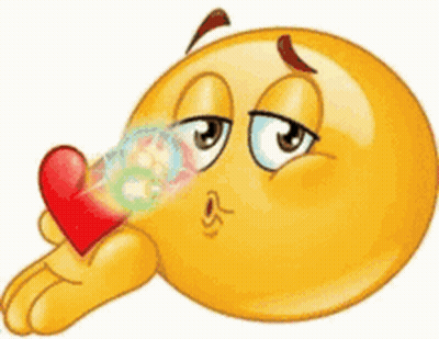 A Cartoon Smiley Face Is Blowing A Kiss While Holding A Red Heart . GIF
