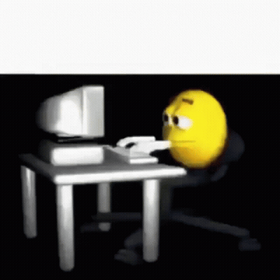 A Cartoon Smiley Face Is Sitting At A Desk In Front Of A Computer . GIF