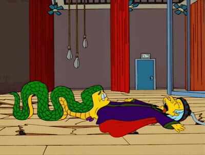 A Cartoon Snake Is Laying On The Floor Next To A Man In A Purple Cape GIF