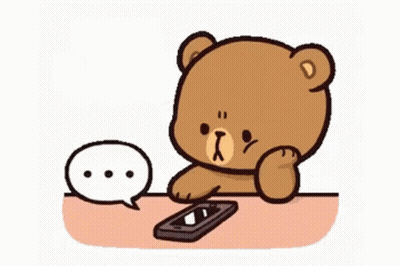 A Cartoon Teddy Bear Is Sitting At A Table With A Cell Phone . GIF