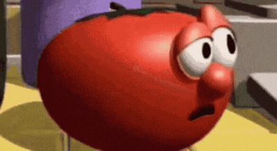 A Cartoon Tomato With A Sad Face Is Standing On A Table . GIF