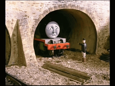 A Cartoon Train With A Sad Face Is Going Through A Tunnel GIF