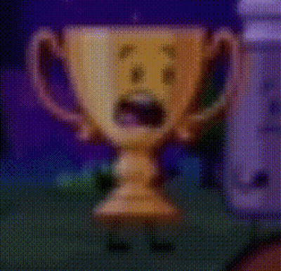 A Cartoon Trophy With A Surprised Face On It Is Standing Next To A Wii Controller . GIF