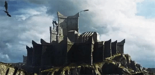A Castle On Top Of A Rocky Hill With Dragons Flying Around It GIF