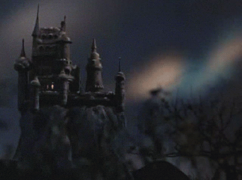 A Castle On Top Of A Snow Covered Hill With Trees In The Foreground GIF