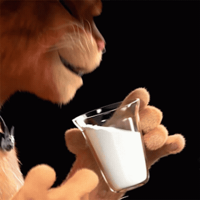 A Cat Is Holding A Glass Of Milk In Its Paw GIF