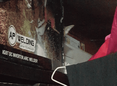 A Cat Is Looking Out Of A Window With A Sign That Says Ap Welding GIF