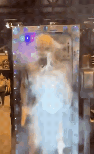 A Cat Is Standing In Front Of A Mirror With Lights On It . GIF