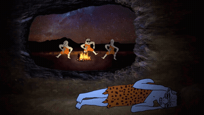 A Caveman Is Laying On The Ground In Front Of A Fire With Three Other Cavemen GIF