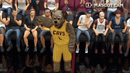 A Cavs Mascot Is Standing In Front Of A Crowd Of People GIF