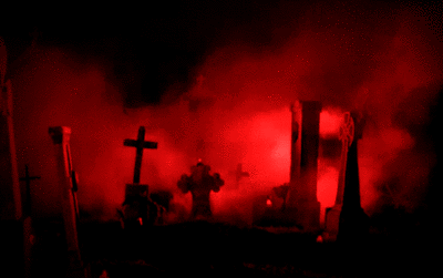 A Cemetery With Red Smoke Coming Out Of The Ground GIF