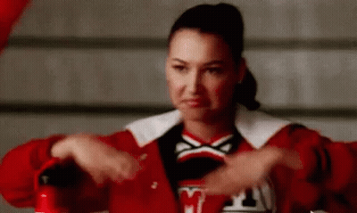A Cheerleader In A Red Jacket Is Holding A Fire Extinguisher In Her Hands . GIF