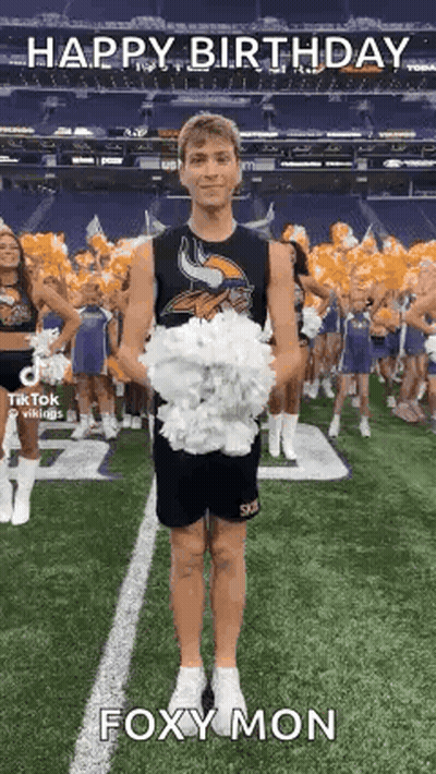 A Cheerleader Is Holding A Bunch Of Pom Poms On A Field . GIF