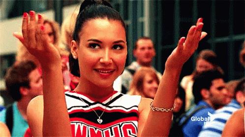 A Cheerleader Wearing A Uniform That Says Wmhs Is Clapping Her Hands . GIF
