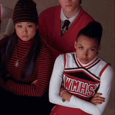 A Cheerleader Wearing A Wmhs Uniform Is Sitting With Her Arms Crossed GIF